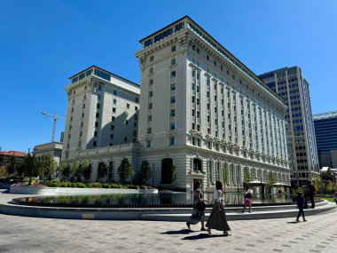 Salt Lake City, Utah, ABD - 29 Eylül 2024: Joseph Smith Memorial Binası, Salt Lake City şehir merkezinde yayalar tarafından çevrelenmiş büyük bir fıskiye ile tarihi neoklasik bir yapı