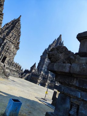 Görkemli antik bir tapınak ayrıntılı taş oymaları sergiliyor, canlı mavi gökyüzünün altında dimdik duruyor.