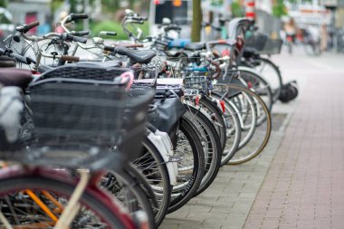 Geniş bir kaldırımda yan yana düzgün bir sıra bisiklet park edilir, yoldan geçenlerin eğlenmesi için canlı bir sahne yaratır.