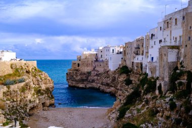 Dik bir uçurumun kenarına kurulmuş küçük bir kasaba aşağıdaki geniş ve sakin su kütlesine tepeden bakan nefes kesici bir manzaraya sahiptir.