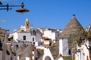 Kalabalık bir şehir, geceleri çevreyi aydınlatan bir sokak lambasının yanında sayısız yüksek binalarla dolu.