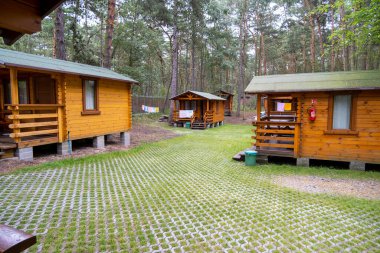 Büyüleyici ahşap kulübelerden oluşan heybetli bir grup, doğal güzelliklerle çevrili, yemyeşil bir ormanın göbeğinde huzur içinde yatıyordu.