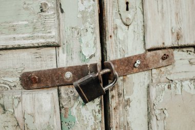 Eski ahşap kapıya asma kilit takılmış.
