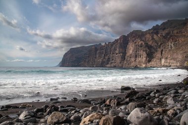 Atlantik Okyanusu 'na ve Los Gigantes tepelerine volkanik kara kumdan Playa de los Guios, Tenerife, Kanarya Adası, İspanya