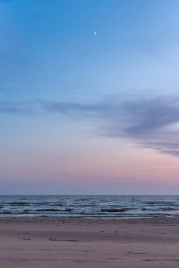 Summer evening after sunset on the Baltic sea beach with new moon clipart