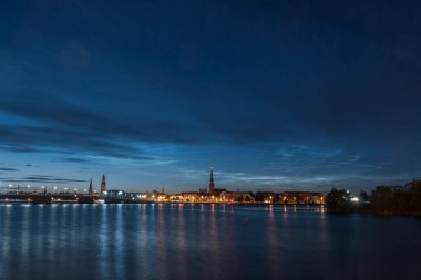 Daugava nehri üzerindeki gece bulutları ve Temmuz gecesi Eski Riga Kasabası ve taş köprü manzarası. Uzun pozlu fotoğrafçılık.