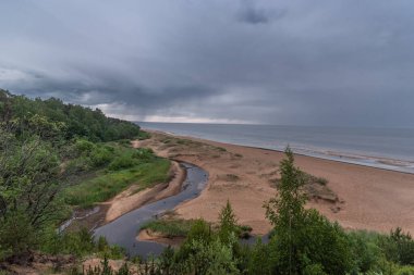 View to the baltic sea and Incupe river from Saulkrasti white dune, Latvia on rainy day clipart