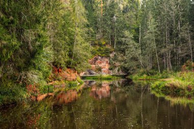 Eylül 'de Letonya' da Brasla nehri üzerindeki kırmızı kumtaşı kayalıkları