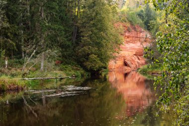 Eylül 'de Letonya' da Brasla nehri üzerindeki kırmızı kumtaşı kayalıkları