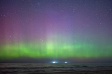 Aurora Borealis İlkbaharda Letonya 'daki Baltık Denizi plajında kuzey ışıkları