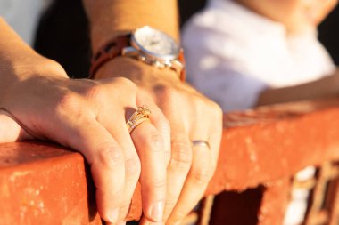 Yüzüklü beyaz elbiseli bir adam ve bir kadının elleri.