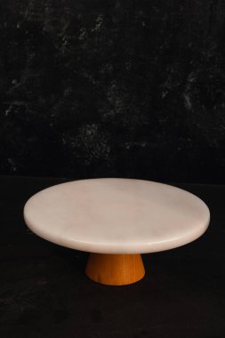 Boş bir mermer tabağı ve Türk kahve öğütücüsüyle rafine ve zarif bir kompozisyon oluşturan minimalist bir yemek tasarımı..