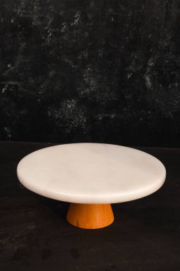 Boş bir mermer tabağı ve Türk kahve öğütücüsüyle rafine ve zarif bir kompozisyon oluşturan minimalist bir yemek tasarımı..