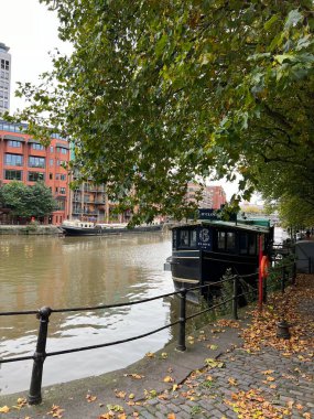 Siyah teknesi ve yemyeşil ağaçları olan şehir kanalı. 