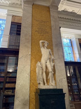 Müzedeki siyah taş üste mermer bir insan heykeli.