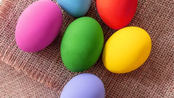 Kahverengi blok arka planında yeşil mor ve kırmızı yumurta