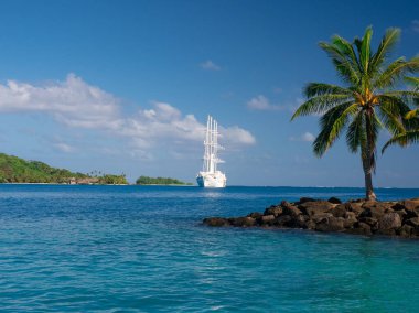 Windstar sail boat anchored in blue waters of Bora Bora clipart