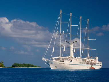 Windstar sail boat anchored in blue waters of Bora Bora clipart