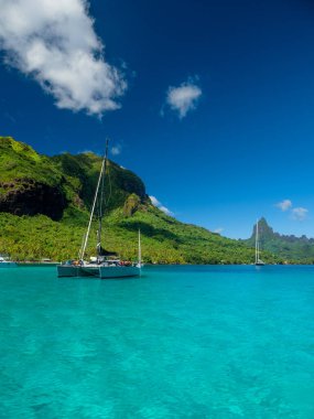 Yacht anchored in blue waters of Moorea clipart