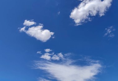 Yumuşak beyaz bulutlarla benekli berrak mavi gökyüzünün nefes kesici bir görüntüsü..