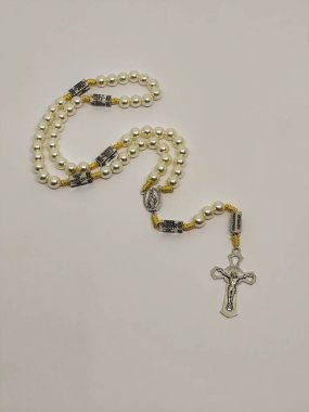 Güzel, beyaz bir inci gerdanlık. Her birimizin içinde gizemlerin ayrıntıları var. İçinde zarif bir haç var..