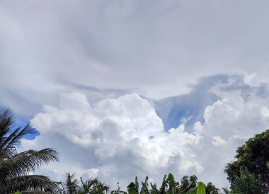 Bulutlu bir gökyüzünün sakin manzarası, beyaz bulutların mavi tonlarla harmanlandığı, güzel bir kontrast oluşturduğu.