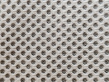 Altıgen ağ desenli bir maddeye yakın çekim, karmaşık ve hassas bir doku içeriyor. Tarafsız renkler aydınlık ve modernlik hissi yaratır, iç tasarım ve moda için idealdir.