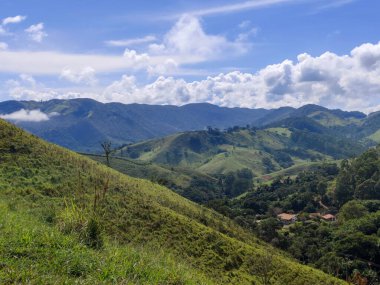 Yumuşak tepeleri ve açık mavi gökyüzü olan yeşil bir manzaranın güzel manzarası..