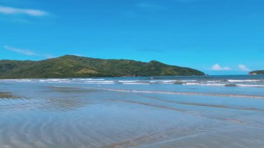 Ubatuba 'daki Fazenda Sahili' nin geniş manzarası, yemyeşil dağlar, geniş kumlu kıyı şeridi, ve ufukta çarpıcı mavi deniz buluşması..
