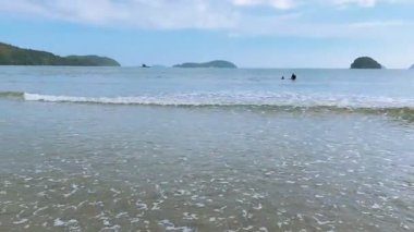 Ubatuba, Brezilya 'daki Ubatumirim Sahili' nde bulutlu bir gökyüzünün altında hafif dalgalar yuvarlanıyor..