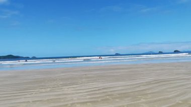 Ubatuba 'daki Fazenda Sahili' nin geniş manzarası, yemyeşil dağlar, geniş kumlu kıyı şeridi, ve ufukta çarpıcı mavi deniz buluşması..