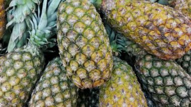 Taze tropikal ananaslar süpermarket üretim bölümünde düzgünce istiflenmiştir. Sağlıklı beslenme, meyve alışverişi, perakende satış veya tropikal tarım konuları için ideal. 