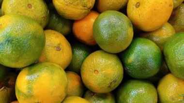 Süpermarketin rafına istiflenmiş taze, olgun portakalların yakın çekimi..