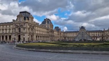 Fransa, Paris 'teki Louvre Müzesi' nin açık hava manzarası. Merkezinde modern cam piramit olan tarihi saray binası.