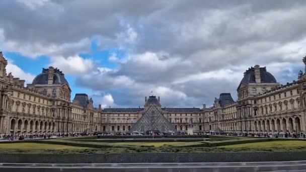 フランスのパリにあるルーブル美術館の外の景色 近代的なガラスピラミッドを中心にした歴史的な宮殿の建物 — ストック動画