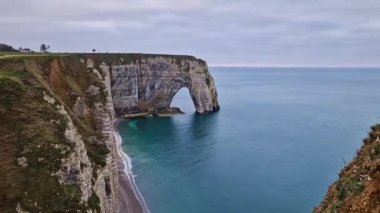 Idyllic view to the Porte d'Aval natural arch at Etretat famous cliffs washed by Atlantic ocean, Normandy, France. Sightseeing coastline scenery, beautiful natural bay with sand beach