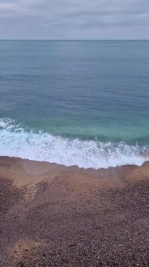 Blue ocean waves hits the shoreline. Beautiful texture of sea water and sandy beach