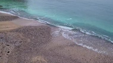 Blue ocean waves hits the shoreline. Beautiful texture of sea water and sandy beach