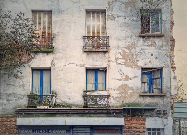 放棄された建物のファサード 窓から成長した木々や茂み 錆びたルーバー コンクリートの壁 — ストック写真