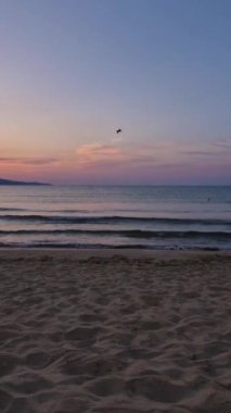 Kumda köpüklü dalgalar ve ufukta renkli gökyüzü ile denizde gün doğumu. Bulgaristan 'da yaz ve seyahat arka planı, Sunny Beach kıyı şeridi