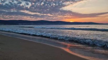 Deniz manzarası, doğal dikey arka plan. Sabahın erken saatlerinde sahilde tepelerin üstündeki güneşin doğuşuna huzurlu bir manzara ile. Sakin yaz tatili, deniz yolculuğu konsepti