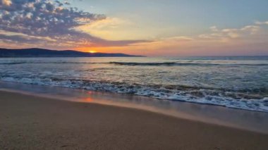 Deniz manzarası, doğal dikey arka plan. Sabahın erken saatlerinde sahilde tepelerin üstündeki güneşin doğuşuna huzurlu bir manzara ile. Sakin yaz tatili, deniz yolculuğu konsepti