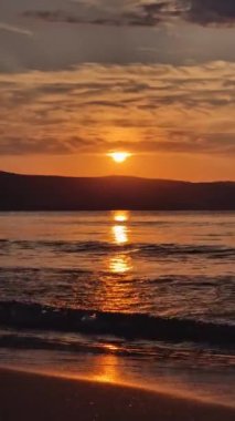 Kumda köpüklü dalgalar ve ufukta renkli gökyüzü ile denizde gün doğumu. Bulgaristan 'da yaz ve seyahat geçmişi, Sunny Beach kıyı şeridi