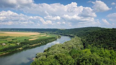 Moldova 'nın Soroca kenti yakınlarındaki Nistru nehir kıyısına yüksek açılı bir manzara. Yeşil vadide dosyada küçük evler olan panoramik bir manzara.
