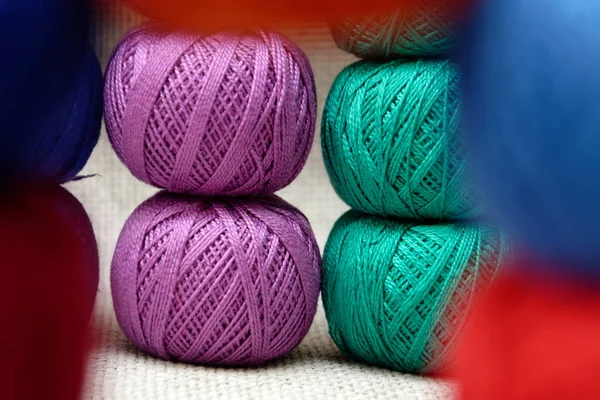 multi-colored skeins of threads stacked one on top of the other, skeins of threads close-up