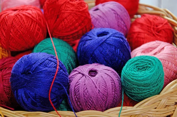 multi-colored skeins of thread in a wicker basket. needlework threads, close-up