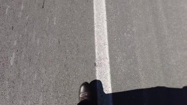 Bir adam yolda yürüyor ve yaya geçidinden geçiyor..