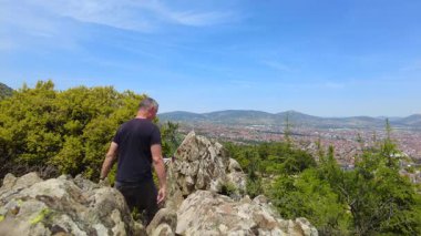 Bir adam yürüyüş sırasında bir kuşun gözünden dağların güzelliğinden zevk alır..