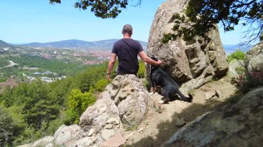 Bir adam ve köpeği dağlarda birlikte vakit geçirmekten zevk alırlar..