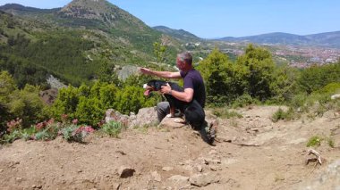 Bir adam ve bir köpek oturup birbirlerine sarılırlar ve zevkle dağlara bakarlar..